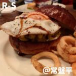 ◎R-S(常盤平)◎ ＊常盤平駅から車で8分 ＊団地にある百名店常連の超人気ハンバーガー屋さん ＊食べログ3.72 　2017-2019年ハンバーガー百名店 ＊リアルバーガー：1,450円 　(半熟エッグ、チーズ、テリヤキソース) 　辛口ジンジャーエール：200円(ランチセット価格) 千葉のハンバーガーで食べログ1位、全国でも30位以内に入る 超人気のハンバーガー店。土日は待つこと必至。 国産和牛100％のR-S BURGERとオージービーフを使用した ORIGIALとPOPULARがあるが、R-S BURGERの中の リアルバーガーを注文。 バンズは近所の人気パン屋さん「ツオップ」のパンを使用。 噛めば噛むほどパンの持つ風味と甘みが出てきて美味しい。 パティは脂の乗りがよく、噛むと口の中で崩れるが、 肉々しくテリヤキソースと半熟エッグの相性抜群。 ただ野菜が入っていなかったのでなかなかずっしりきて 終盤は少し重くなってきてしまった。 次回は野菜も入ったTheバーガーを注文しよう。 ★★★★★★★☆☆☆